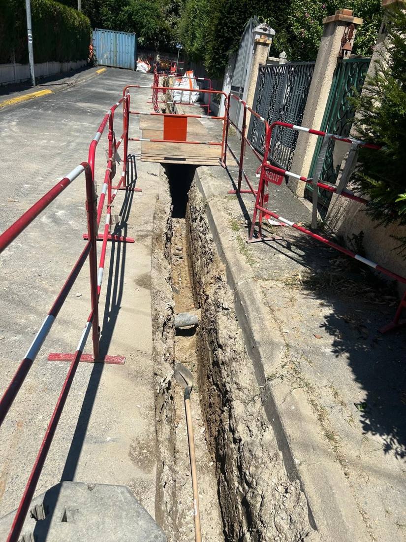 Tranchée étroite balisée le long d'un trottoir