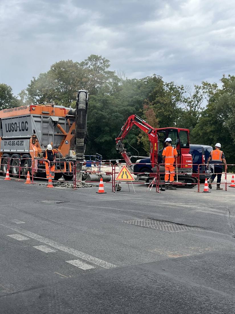 Équipe et pelle sur un chantier de branchement balisé